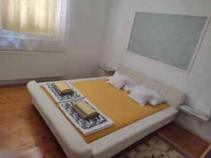 a small room with a bed with two pillows at Apartman Centar in Kruševac