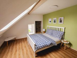 um quarto com uma cama e paredes verdes em Apartmány u Koláčků em Hartmanice