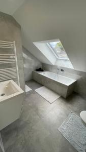 a bathroom with a sink and a bath tub at Moderne Dachgeschosswohnung Modern Apartment in Rastatt