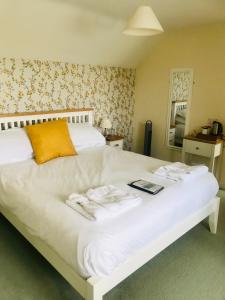 um quarto com uma cama branca com um livro em Bransford Farm Fishery & B & B em Bransford