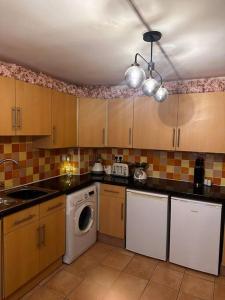 a kitchen with a washing machine and a washer at Cosy Herne Bay Seaside Cottage in Kent