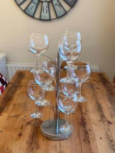 un grupo de copas de vino sentadas en una mesa de madera en Cosy Herne Bay Seaside Cottage, en Kent