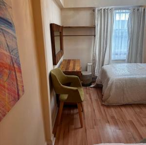 a bedroom with a bed and a chair and a desk at Cosy Herne Bay Seaside Cottage in Kent