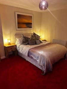 een slaapkamer met een bed met rode loper bij Cosy Herne Bay Seaside Cottage in Kent