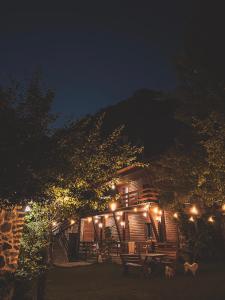 una cabaña iluminada por la noche con luces en Guesthouse Pashko, en Theth