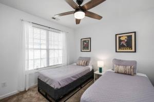 a bedroom with two beds and a ceiling fan at DT/2 Spacious 3BR Suites/FreeParking/SelfCheckin in Raleigh