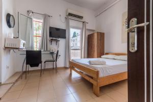 ein Schlafzimmer mit einem Bett und einem Schreibtisch. in der Unterkunft Hotel Loui Talpiot in Haifa