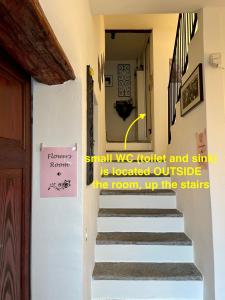 Una escalera con un letrero que se lee pequeño que probamos y cantamos está cerrada afuera en 1912 - Flowers Room - budget for young, en Locarno