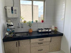 a small kitchen with a sink and a window at Boho - By Great Impressions in Pune +20 photos