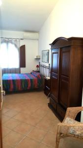 a bedroom with a bed and a dresser at B&B Brezza di Mare (Sea Breeze) in Villasimius