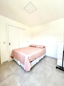 a bedroom with a bed with a pink blanket at Apto 3 quartos no Wai Wai - Cumbuco-Ce in Cumbuco