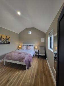 una camera con un grande letto e un pavimento in legno di Rose Meadow Lodge a Liscannor