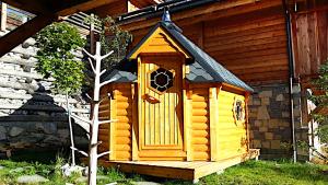 a small wooden house with a door on the side of a house at Prestigious 18 Person Chalet with Pool and Jacuzzi in Vars