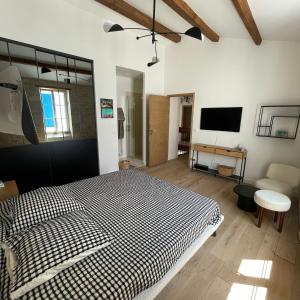 a bedroom with a black and white bed and a tv at L'OCEAN a Oleron in Le Château-dʼOléron
