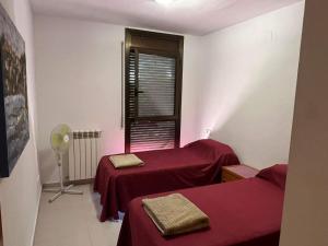 a room with two beds and a window at Casa Mequinenza in Mequinenza