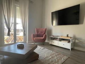 uma sala de estar com uma cadeira e uma televisão em Centrally Located Spacious Private Apartment BuenaVista in Grao with Rooftop em Grao de Castellón