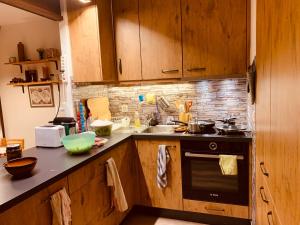 uma cozinha com armários de madeira, um lavatório e um fogão em Appartement de vacances à Torgon em Vionnaz