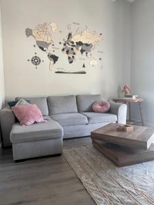 a living room with a couch and a world map on the wall at Centrally Located Spacious Private Apartment BuenaVista in Grao with Rooftop in Grao de Castellón