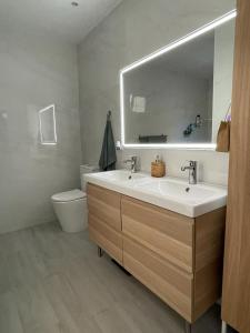 a bathroom with a sink and a toilet and a mirror at Centrally Located Spacious Private Apartment BuenaVista in Grao with Rooftop in Grao de Castellón