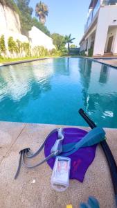 a purple bag with a watch next to a swimming pool at Appartement en bord de mer in Pont Blondin