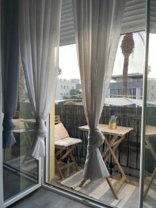 a patio with curtains and a table and a table and chairs at Centrally Located Spacious Private Apartment BuenaVista in Grao with Rooftop in Grao de Castellón