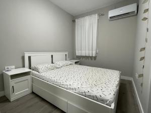 - une petite chambre avec un lit blanc et une fenêtre dans l'établissement Centrally Located Spacious Private Apartment BuenaVista in Grao with Rooftop, à Grao de Castellón