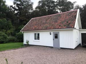 een wit gebouw met een rood dak bij Liten stuga i Haverdal in Haverdal