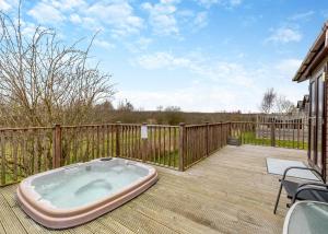 a hot tub sitting on a wooden deck at Ashby Woulds Lodges And Spa in Moira
