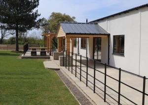 a small house with a porch and a fence at Bredon View in Pershore