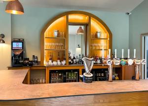a bar in a room with a large mirror at Bredon View in Pershore