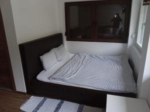 ein kleines Bett in einem Zimmer mit Fenster in der Unterkunft Zicka plaza in Kraljevo