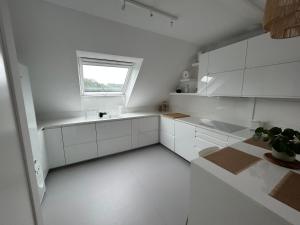 a white kitchen with a sink and a window at Appartement Nuage blanc in Bitche