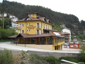 a large yellow building on the side of a mountain at Kris Hotel & Restaurant in Smolyan