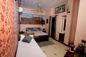 Banaji Heritage Haveli في جودبور: غرفة نوم فيها سرير واريكة