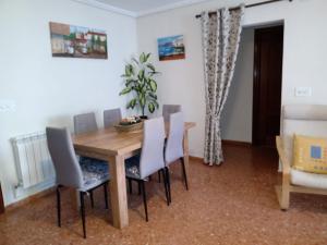 uma sala de jantar com uma mesa de madeira e cadeiras em Apartamento a 200m de Playa Morrongo em Benicarló