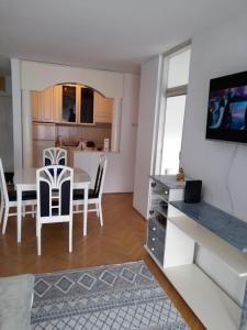ein Wohnzimmer und eine Küche mit einem Tisch und Stühlen in der Unterkunft Apartman Nina in Banja Luka