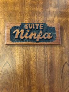 een bord op een houten tafel met de woorden suite ninja bij Ninfa Alghero in Alghero