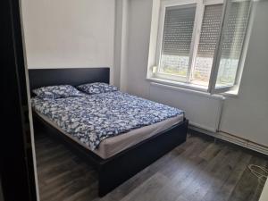 ein Bett in einem Schlafzimmer mit zwei Fenstern in der Unterkunft Apartament Gara de Nord in Bukarest