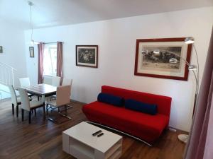 a living room with a red couch and a table at Art House by Dimai in Dornbirn