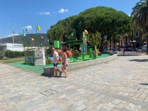a man and a woman walking by a playground at Central Sestri Executive 2 Bedroom&Huge Terrace in Sestri Levante