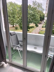 a window with a chair on a balcony at Joli appartement proche métro in Lyon