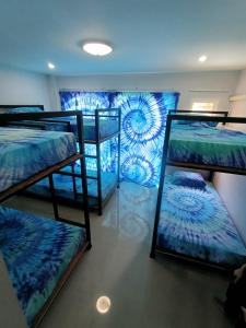 a room with three bunk beds with blue sheets at Freedom​ Hostel​ in Khao Lak