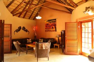- un salon avec un canapé et une table dans l'établissement Bona Intaba Game Lodge, à Hoedspruit
