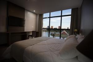 a bedroom with a large bed and a large window at Bello Hotel in Toledo