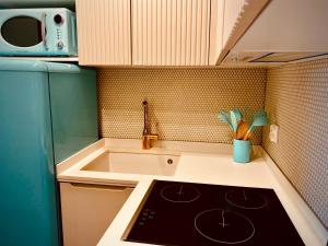 a kitchen with a stove top oven next to a sink at Apartament CZOS in Mrągowo