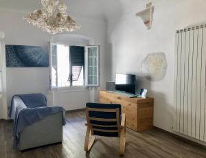 ein Wohnzimmer mit einem Stuhl und einem Schreibtisch mit einem Computer in der Unterkunft Marco's House in Lavagna