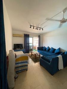 uma sala de estar com dois sofás azuis e uma lareira em الساحل الشمالي em Abû Zeira