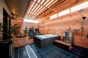La salle de bains est pourvue d'une baignoire dans un mur en bois. dans l'établissement R.Kamakura, à Kamakura