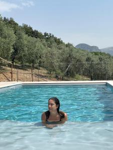 a woman is sitting in a swimming pool at Agriturismo Il Casaletto in Montefranco