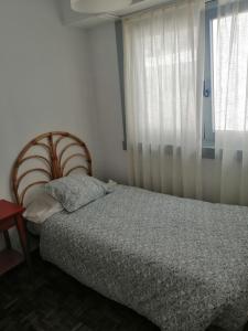 a bedroom with a bed and a window at Apartamento Costa Riazor Coruña in A Coruña